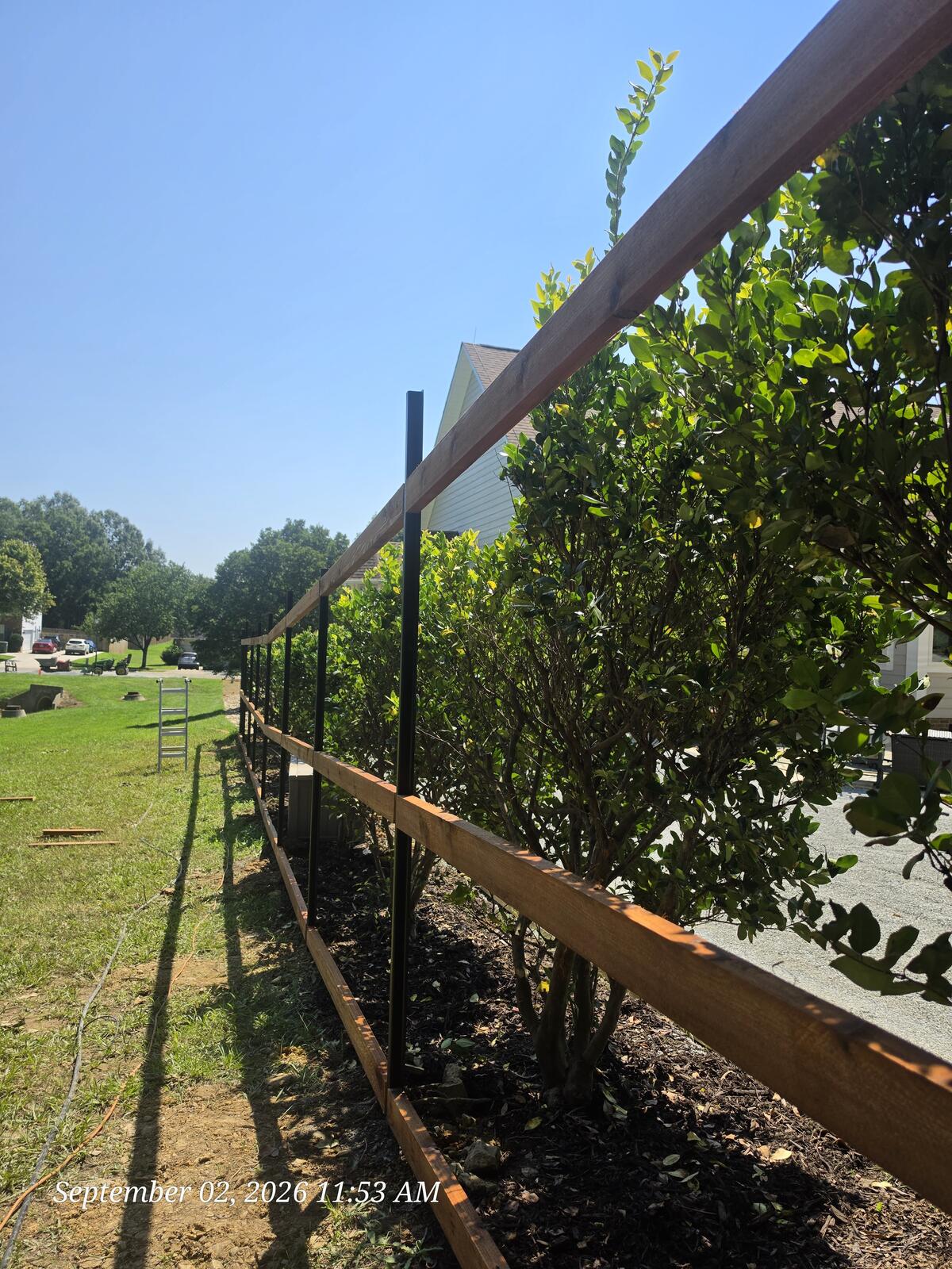 Cedar rails on steel posts during custom fence build Monroe NC