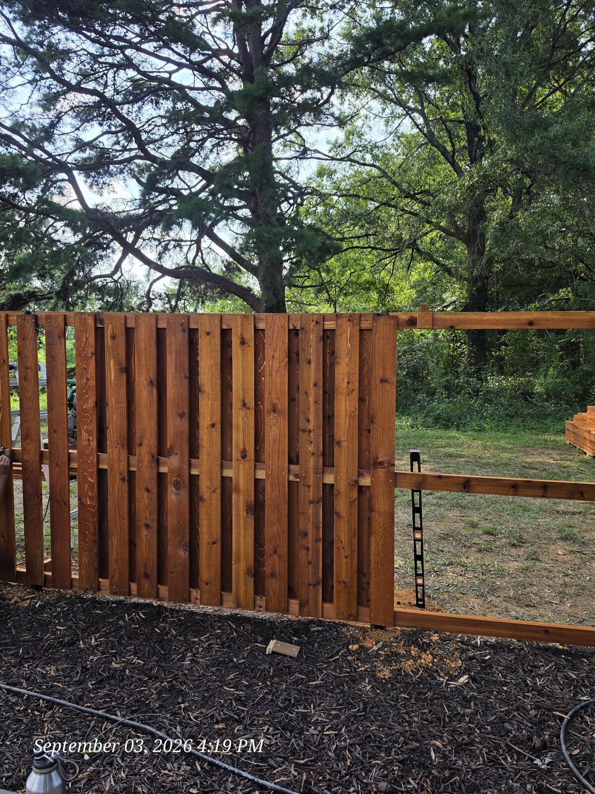 Shadowbox cedar pickets being installed on steel posts Monroe NC